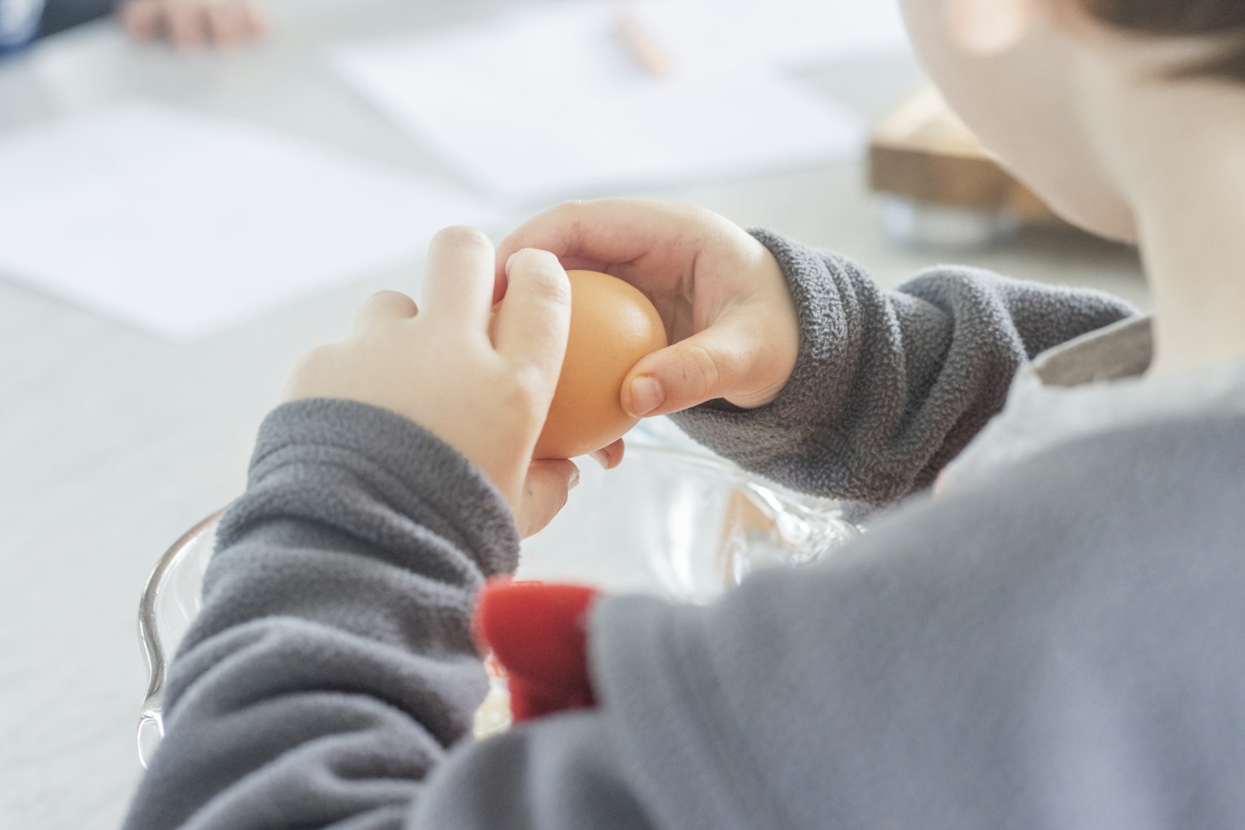 An adult hand gently holding a small child's hand